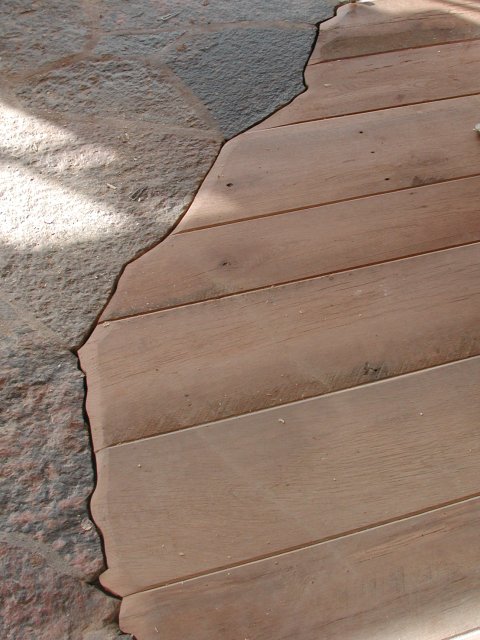 Oak hardwood flooring meeting up against natural stone floors